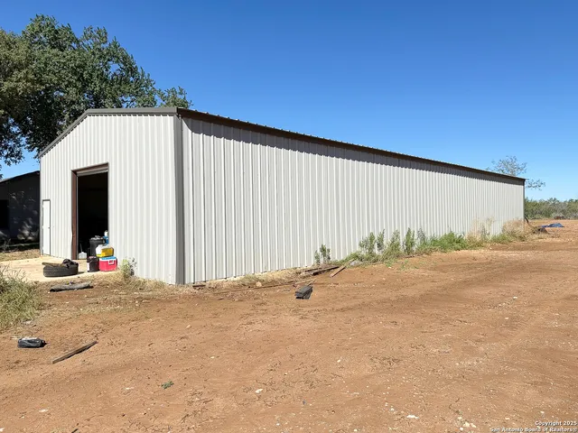 a backyard of a house with garage and outdoor seating
