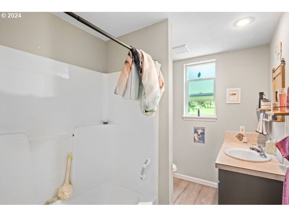 6034 Treehouse Road Monmouth, OR 97361 - Photo 30 of 45 a bathroom with a sink a mirror and a shower