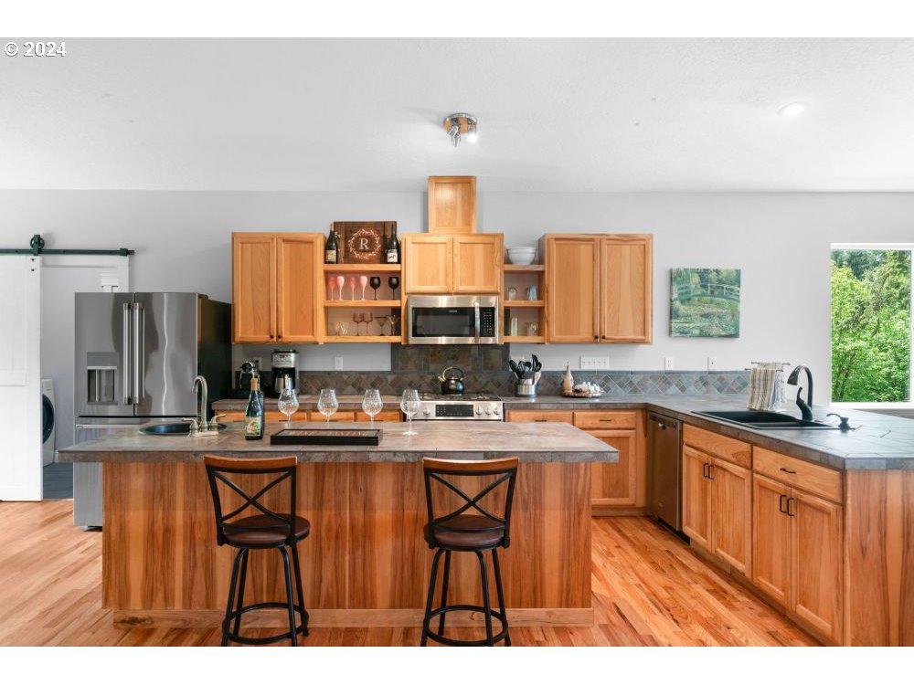 6034 Treehouse Road Monmouth, OR 97361 - Photo 6 of 45 a kitchen with stainless steel appliances a sink stove and refrigerator