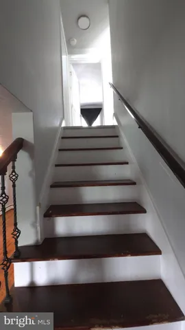 a view of a hallway with wooden floor and closet