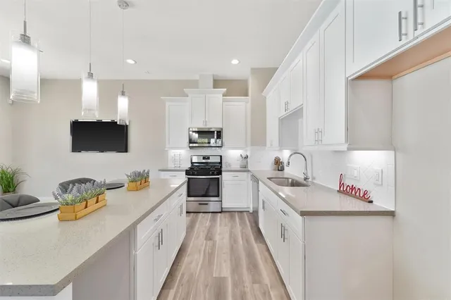 a large white kitchen with stainless steel appliances