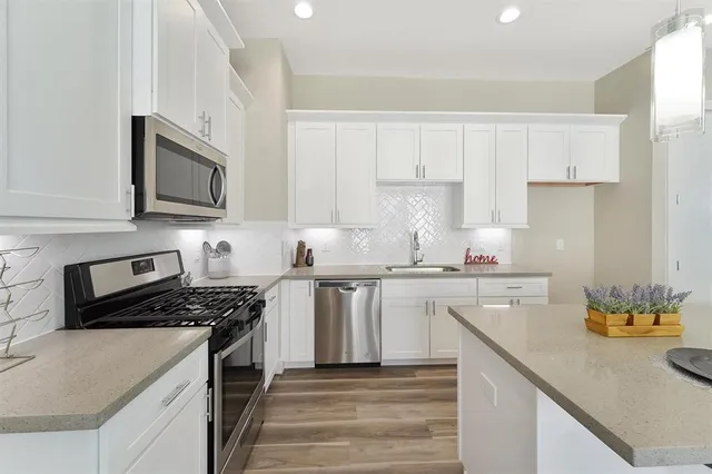 a kitchen with cabinets stainless steel appliances and a counter space