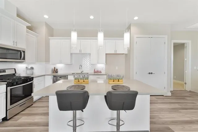 a kitchen with stainless steel appliances granite countertop a stove a refrigerator a sink a counter top space and cabinets