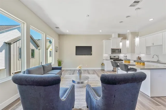 a living room with furniture kitchen and a large window