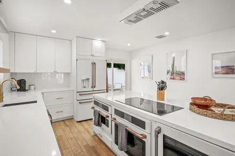 a kitchen with white cabinets and white appliances