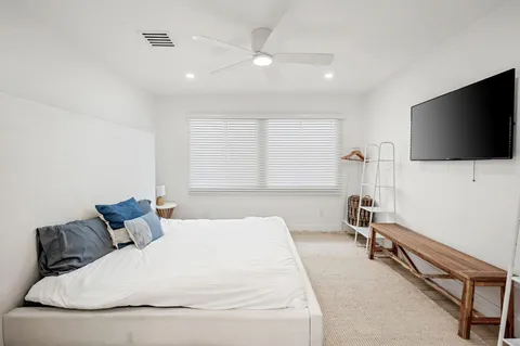 a bedroom with a bed and a flat screen tv