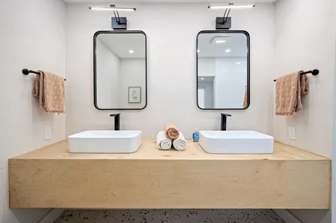 a bathroom with double vanity sinks and two mirror