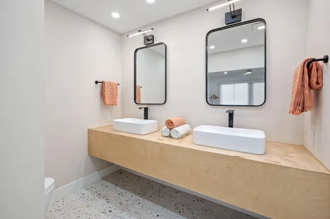 a bathroom with double vanity sinks and a mirror