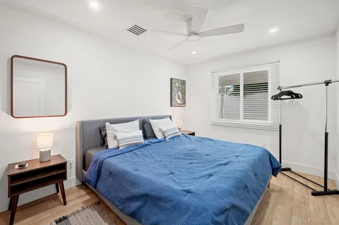 a bedroom with a bed wooden floor and window