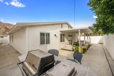 a roof deck with table and chairs under an umbrella