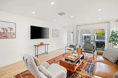 a living room with furniture a flat screen tv and wooden floor