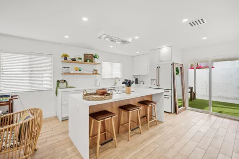 a kitchen with stainless steel appliances granite countertop a sink and a refrigerator