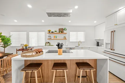 a kitchen with a sink a stove and chairs
