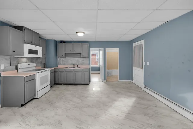 a large white kitchen with cabinets and a sink