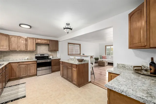 a kitchen with stainless steel appliances granite countertop a stove top oven a sink a counter space and cabinets