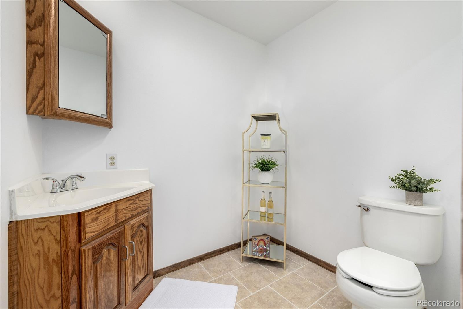 10095 West 41st Avenue Wheat Ridge, CO 80033 - Photo 14 of 37 a bathroom with a sink a toilet and mirror