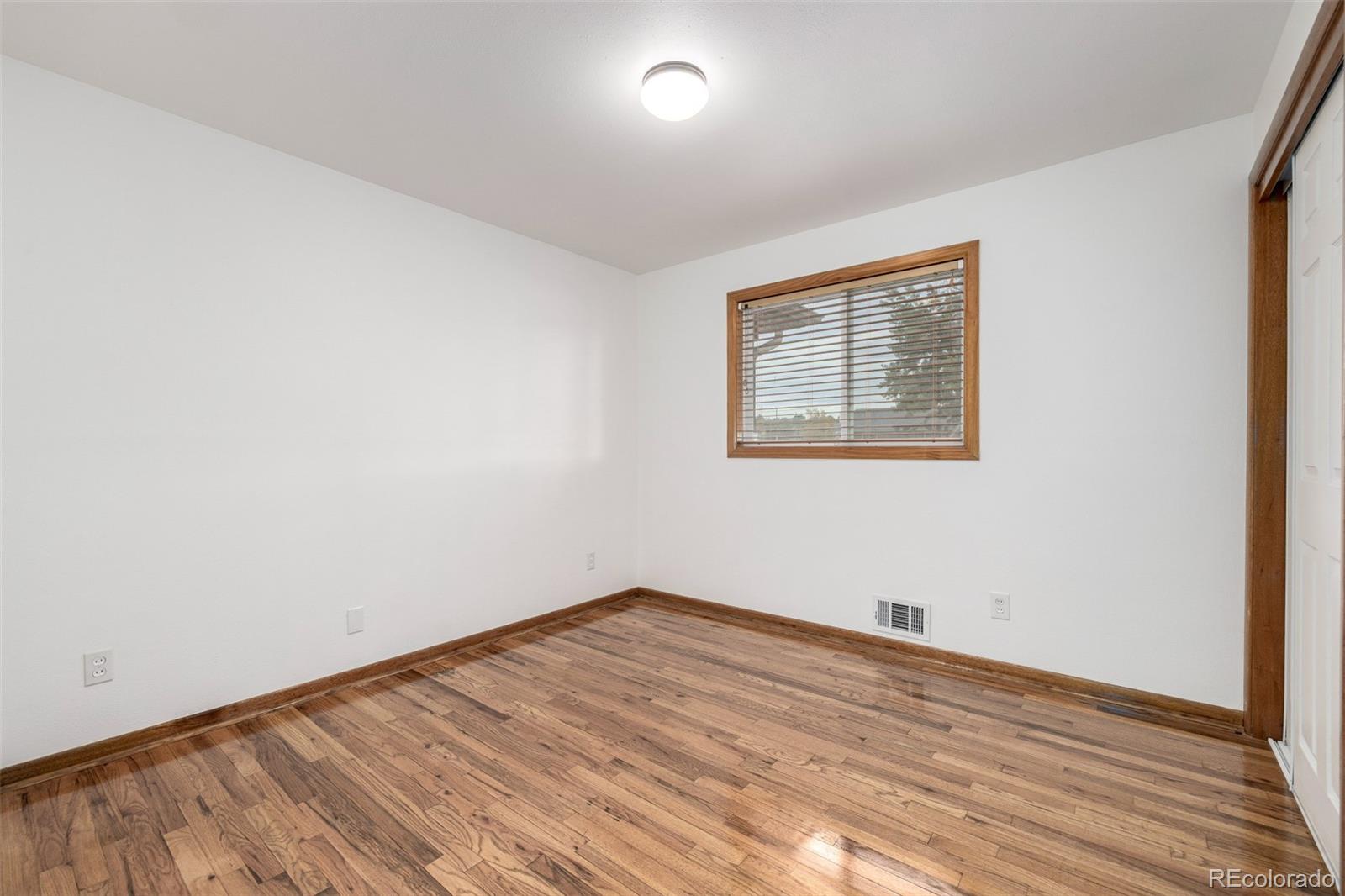 10095 West 41st Avenue Wheat Ridge, CO 80033 - Photo 18 of 37 an empty room with wooden floor and windows