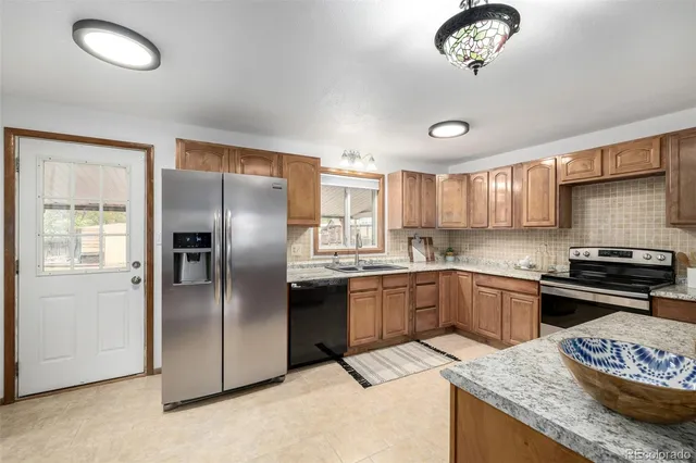 a kitchen with stainless steel appliances granite countertop a sink stove and refrigerator