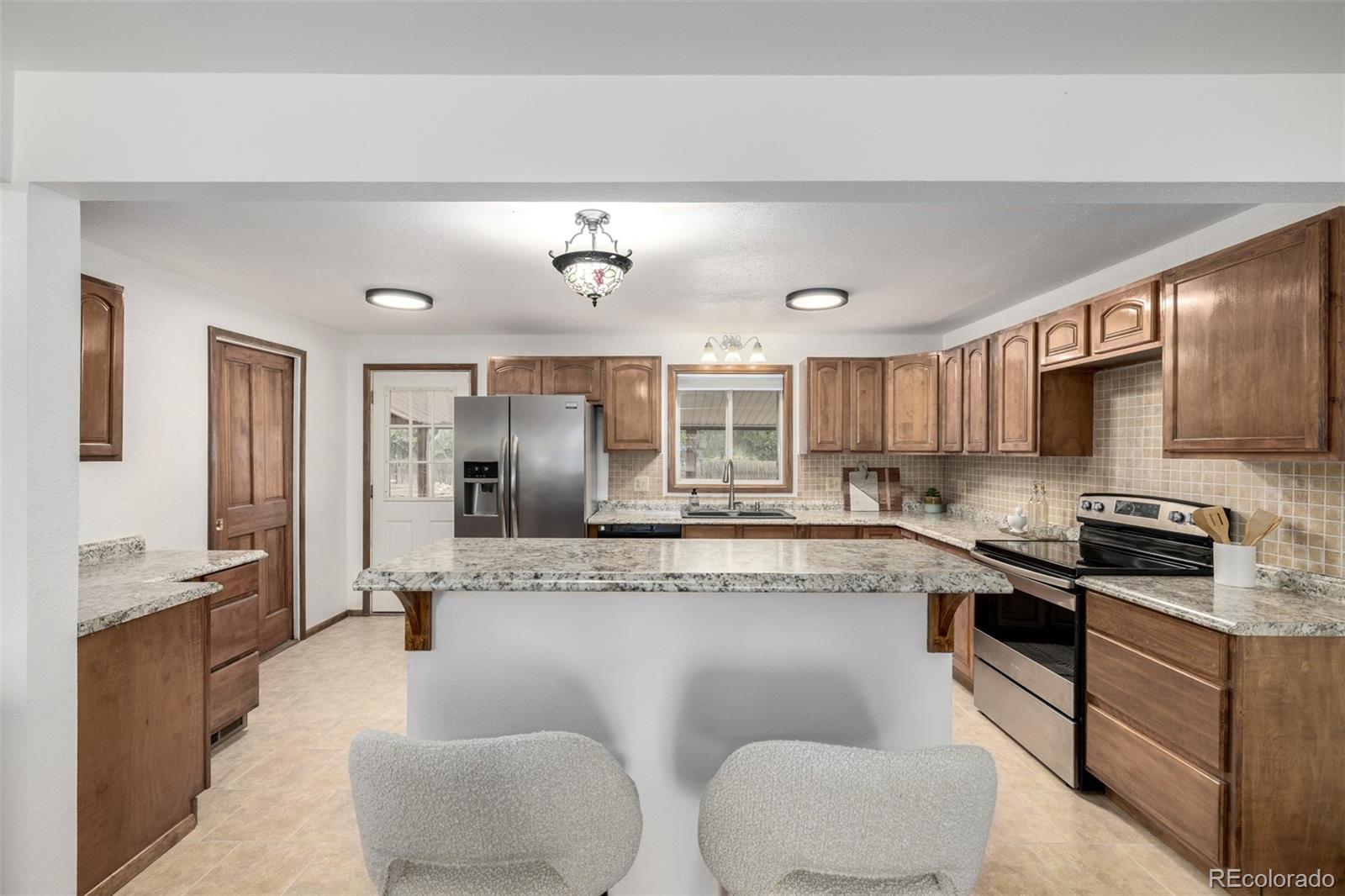 10095 West 41st Avenue Wheat Ridge, CO 80033 - Photo 10 of 37 a large kitchen with stainless steel appliances granite countertop a sink and cabinets