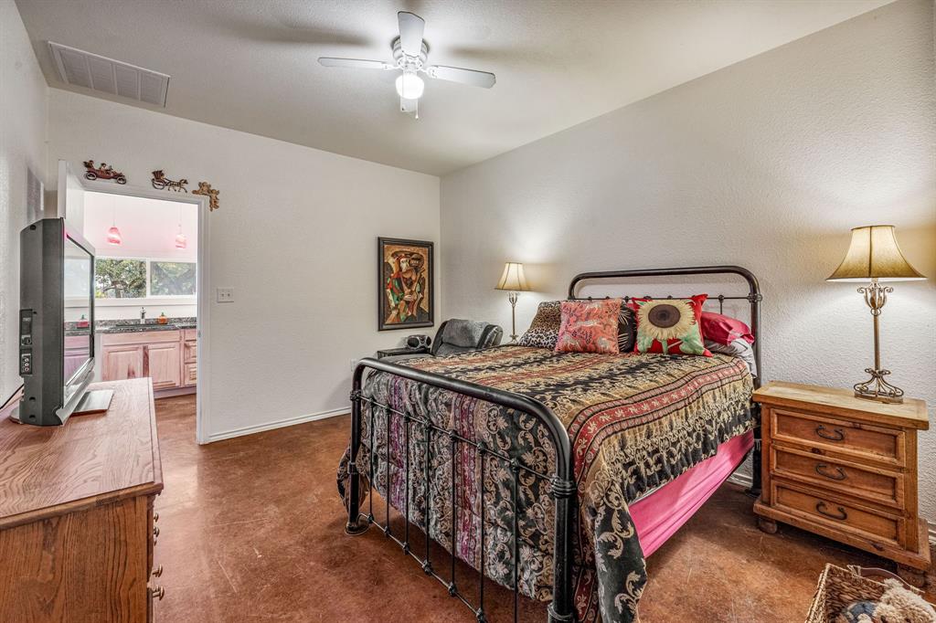 255 Baughman Hill Road Azle, TX 76020 - Photo 15 of 40 a bedroom with a bed and a flat tv screen on the dresser
