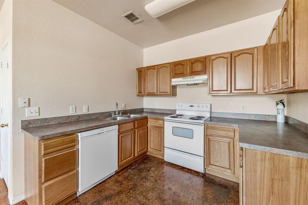 255 Baughman Hill Road Azle, TX 76020 - Photo 31 of 40 a kitchen with stainless steel appliances granite countertop a sink stove and cabinets