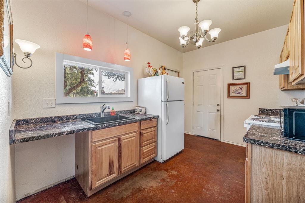 255 Baughman Hill Road Azle, TX 76020 - Photo 10 of 40 a kitchen with stainless steel appliances granite countertop a refrigerator a sink dishwasher and white cabinets with wooden floor