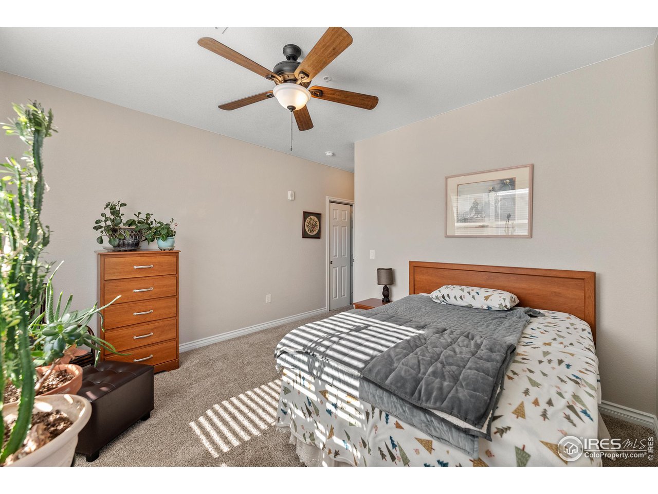 4672 West 20th Road, Unit 723 Greeley, CO 80634 - Photo 17 of 27 a bedroom with a bed and a painting on the wall