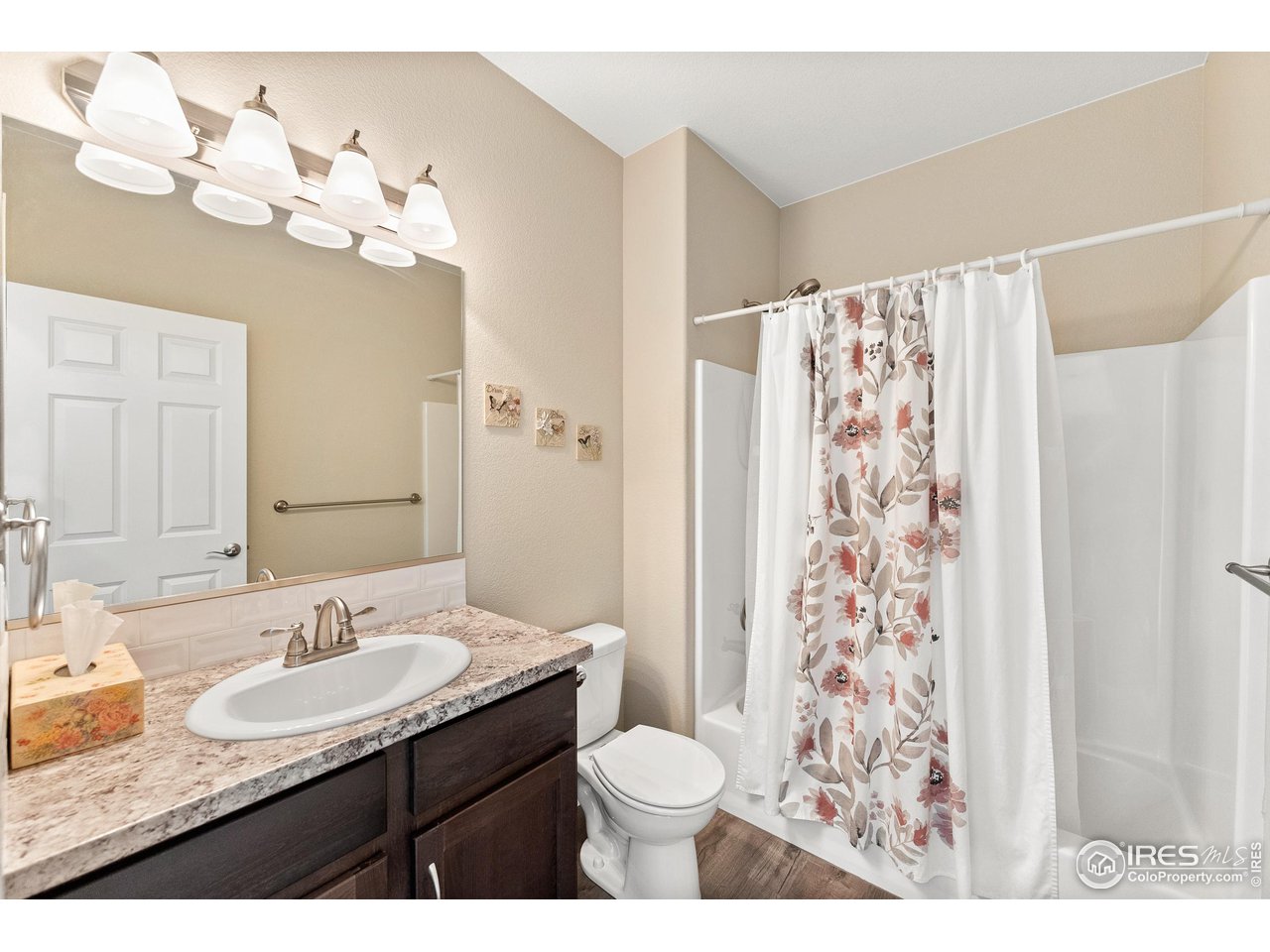 4672 West 20th Road, Unit 723 Greeley, CO 80634 - Photo 21 of 27 a bathroom with a granite countertop sink toilet a mirror and shower curtain