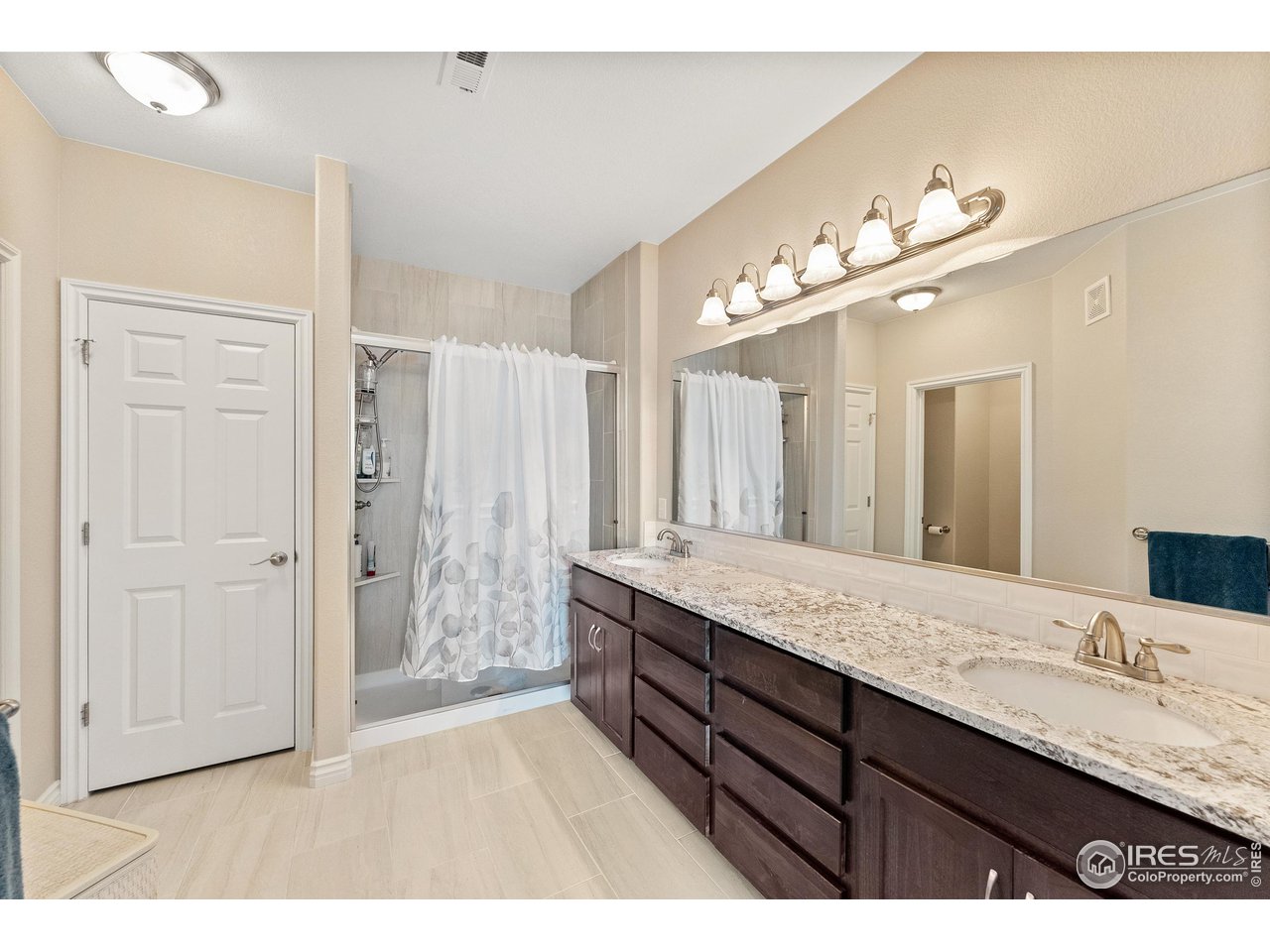4672 West 20th Road, Unit 723 Greeley, CO 80634 - Photo 23 of 27 a bathroom with a granite countertop double vanity sink and a mirror
