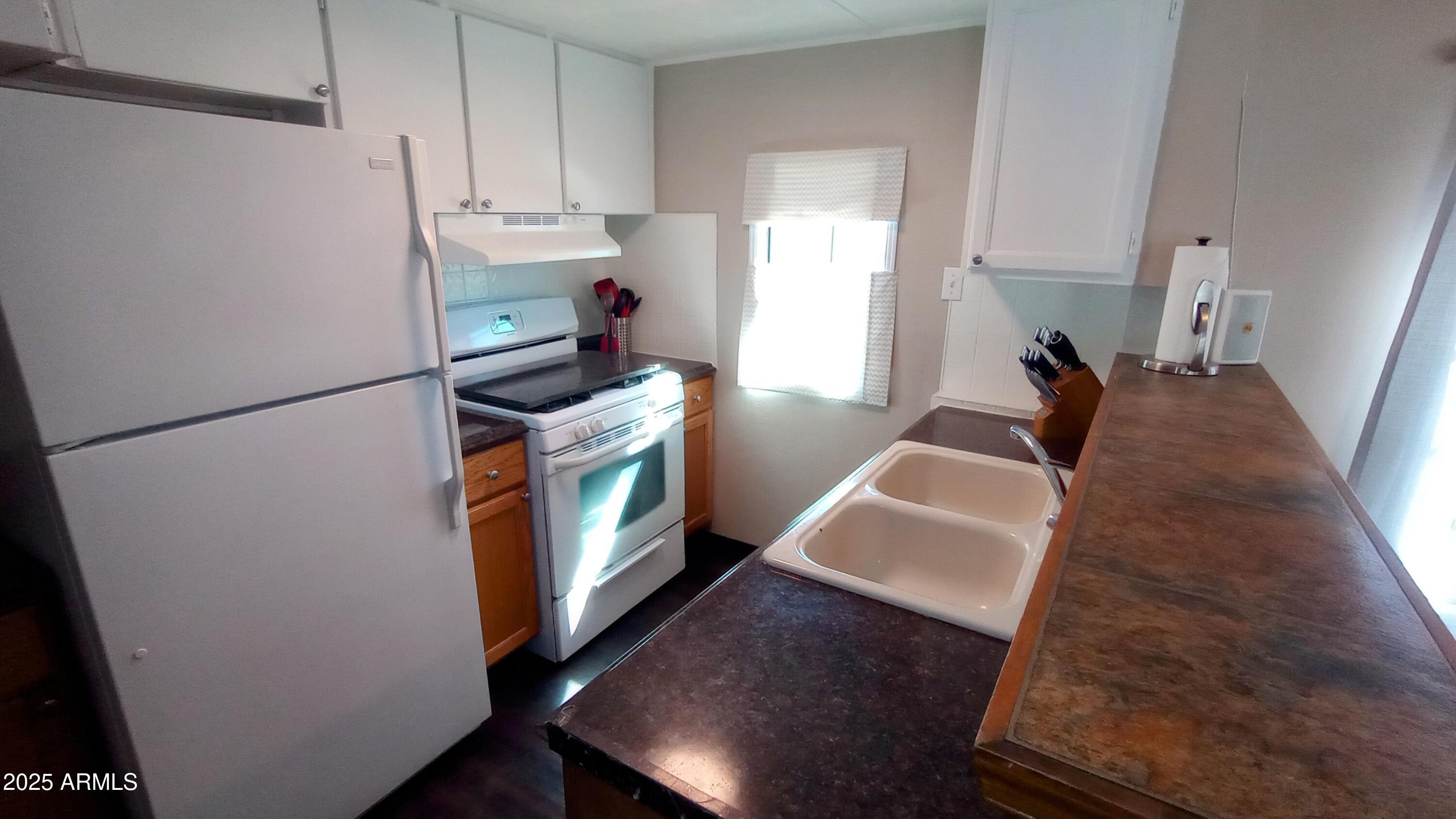 269 North Winchester Road, Unit 2 Apache Junction, AZ 85119 - Photo 9 of 36 a kitchen with wooden floor and electronic appliances