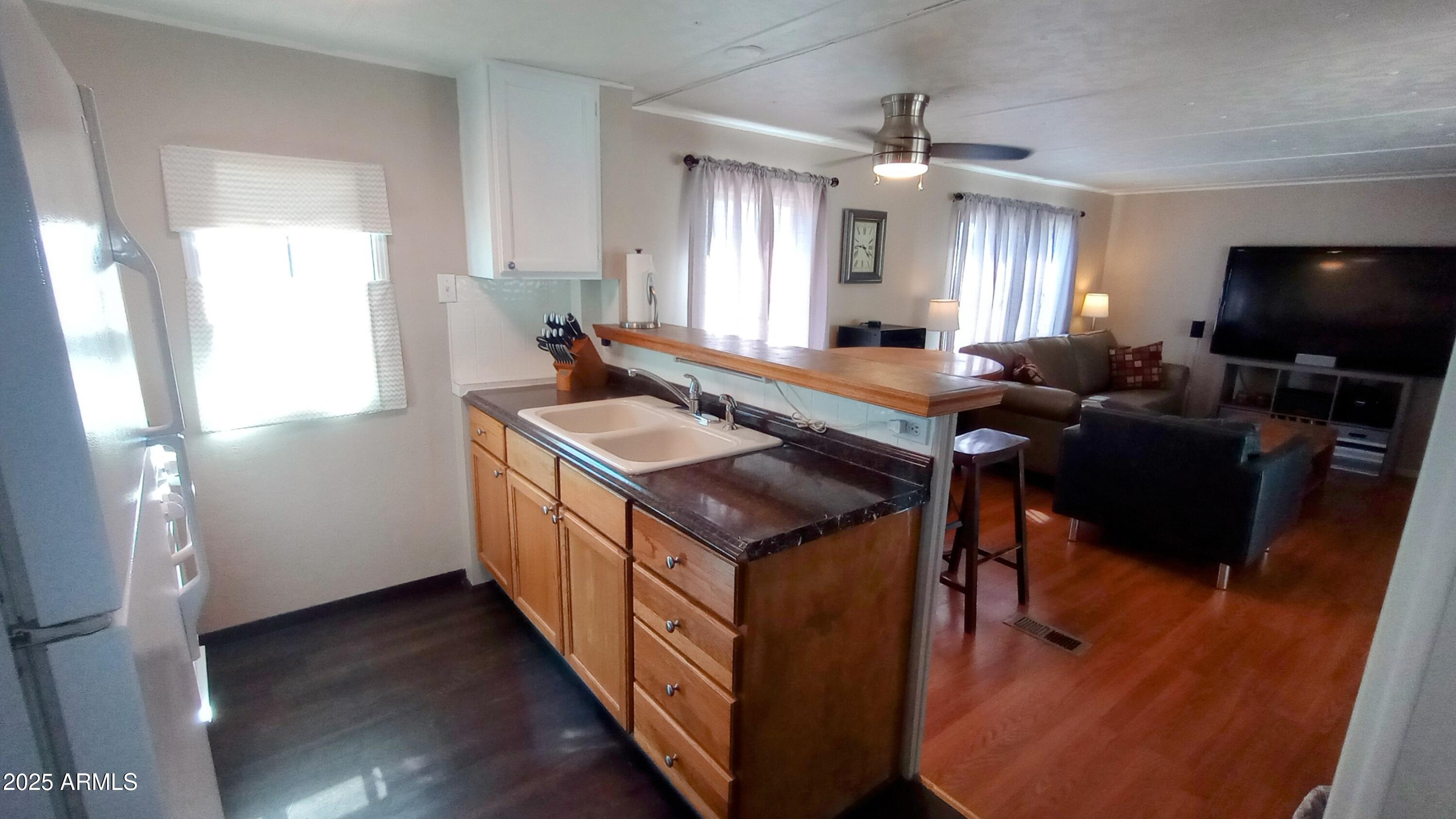 269 North Winchester Road, Unit 2 Apache Junction, AZ 85119 - Photo 10 of 36 a kitchen with stainless steel appliances granite countertop a sink a stove and a wooden floors
