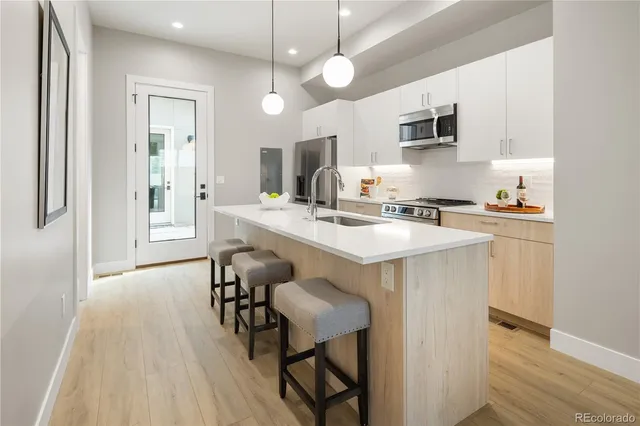 a kitchen with a table chairs microwave and cabinets