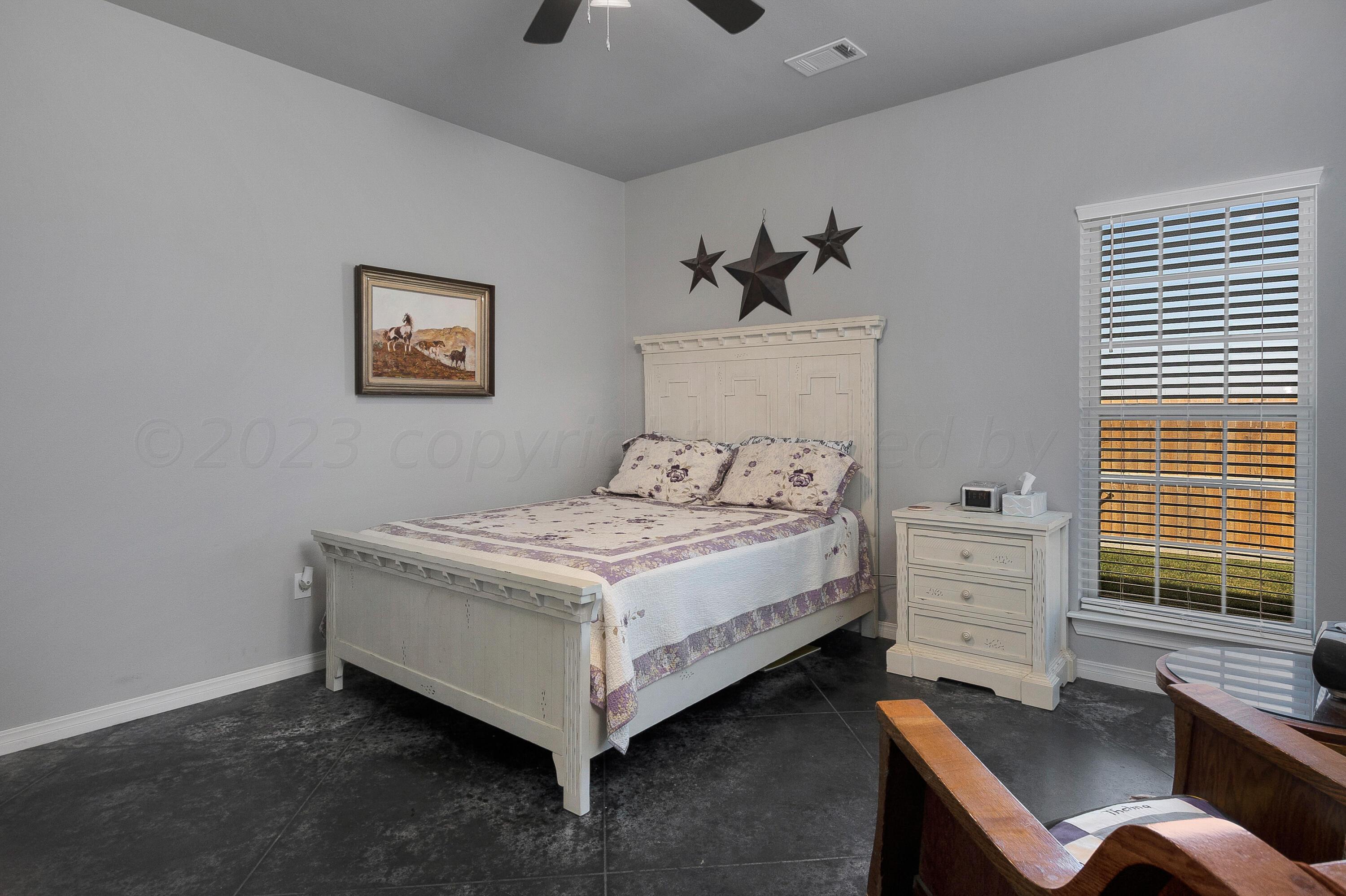 9927 Perry Avenue Amarillo, TX 79119 - Photo 12 of 24 a bedroom with a bed and a desk