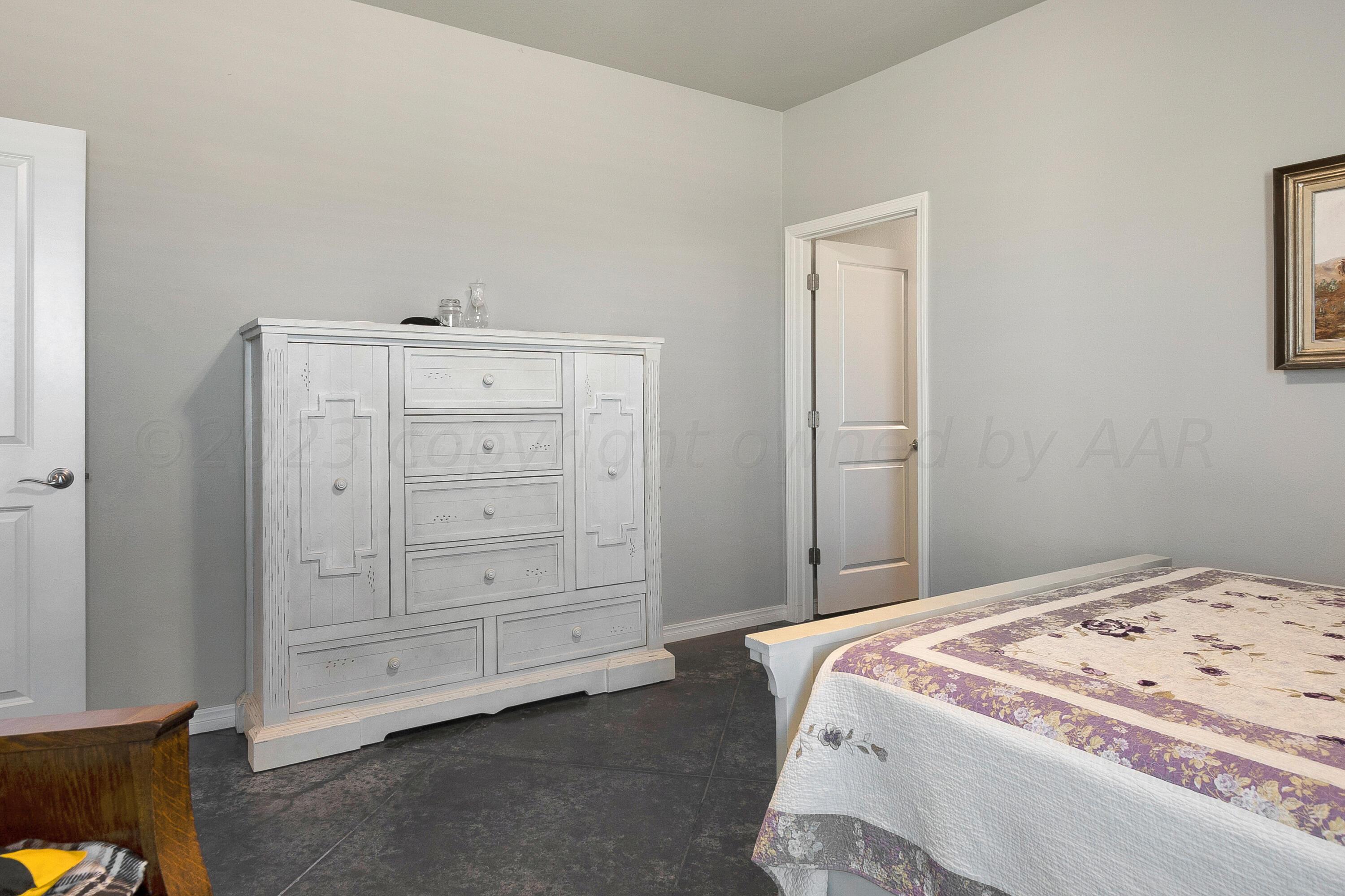 9927 Perry Avenue Amarillo, TX 79119 - Photo 13 of 24 a bedroom with a bed and a cabinets
