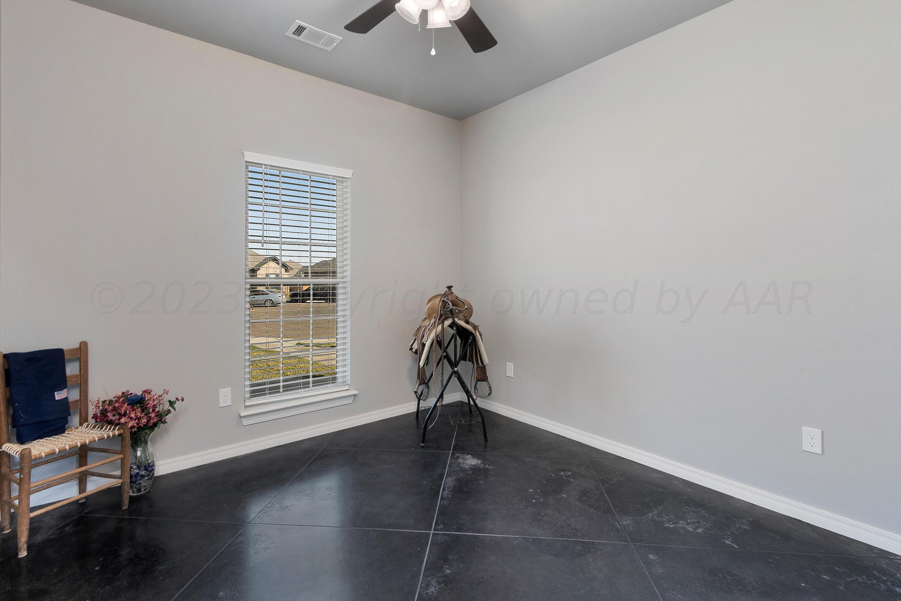 9927 Perry Avenue Amarillo, TX 79119 - Photo 17 of 24 an empty room with windows and ceiling fan