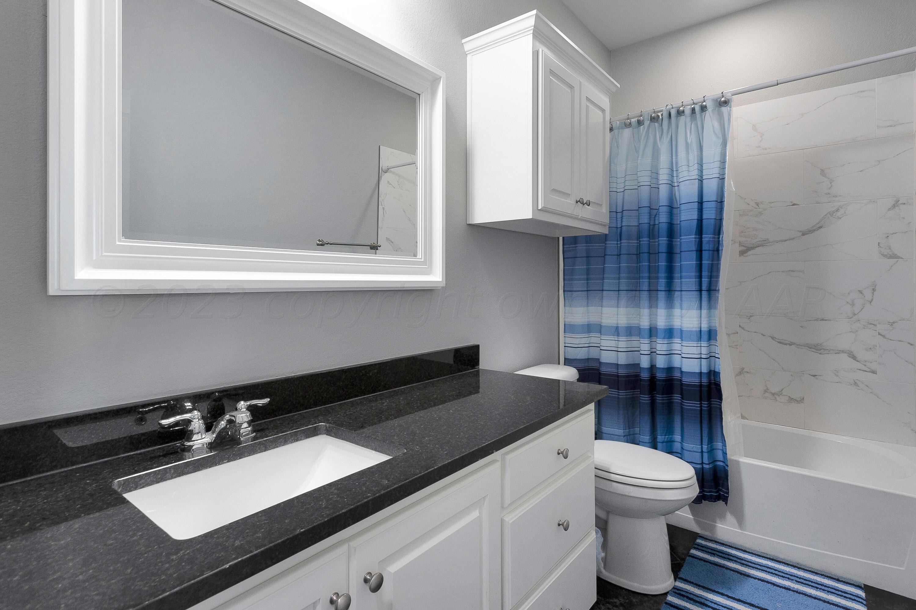 9927 Perry Avenue Amarillo, TX 79119 - Photo 18 of 24 a bathroom with a sink a toilet and shower