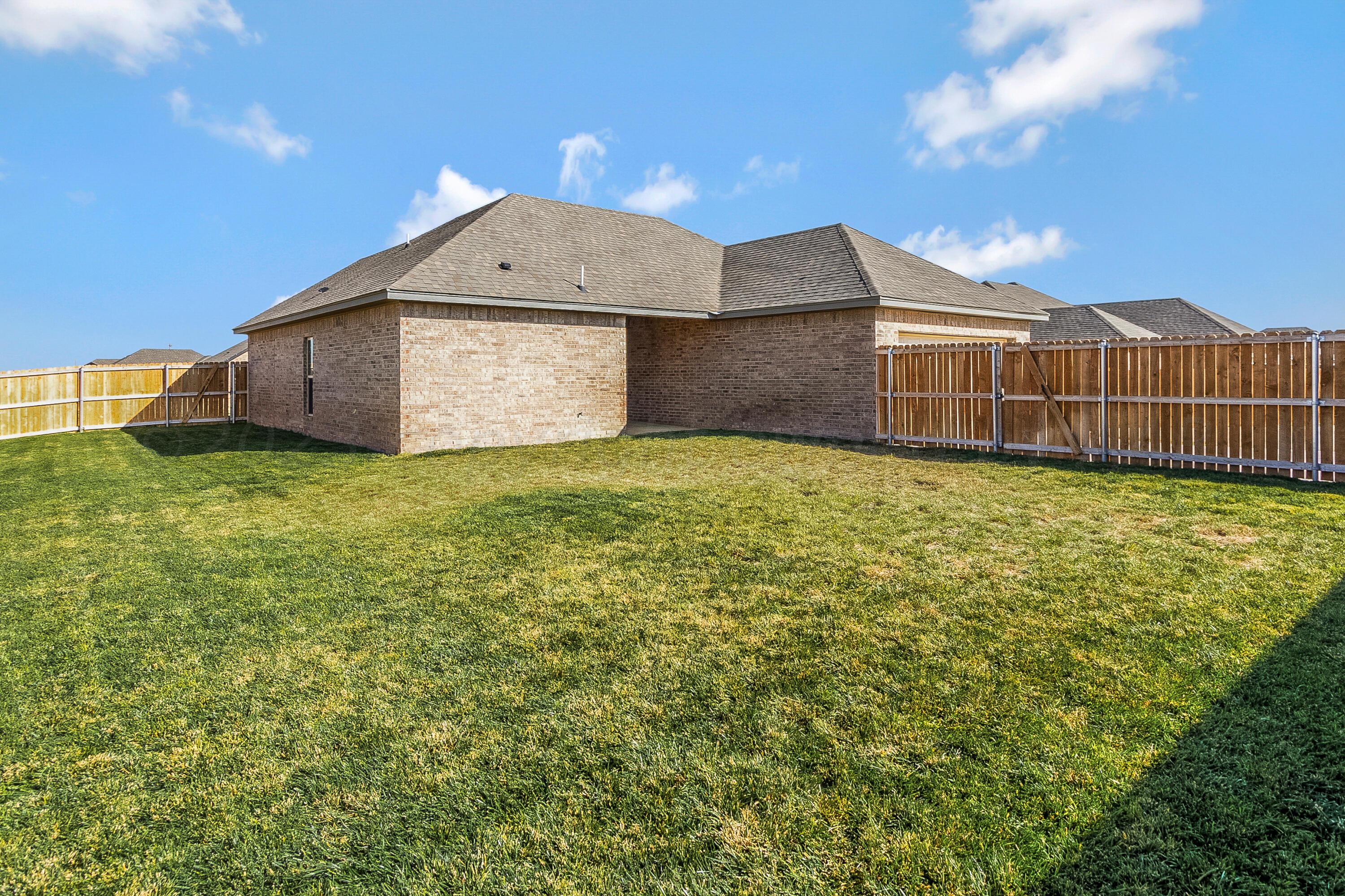 9927 Perry Avenue Amarillo, TX 79119 - Photo 20 of 24 a view of a house with a yard and garage