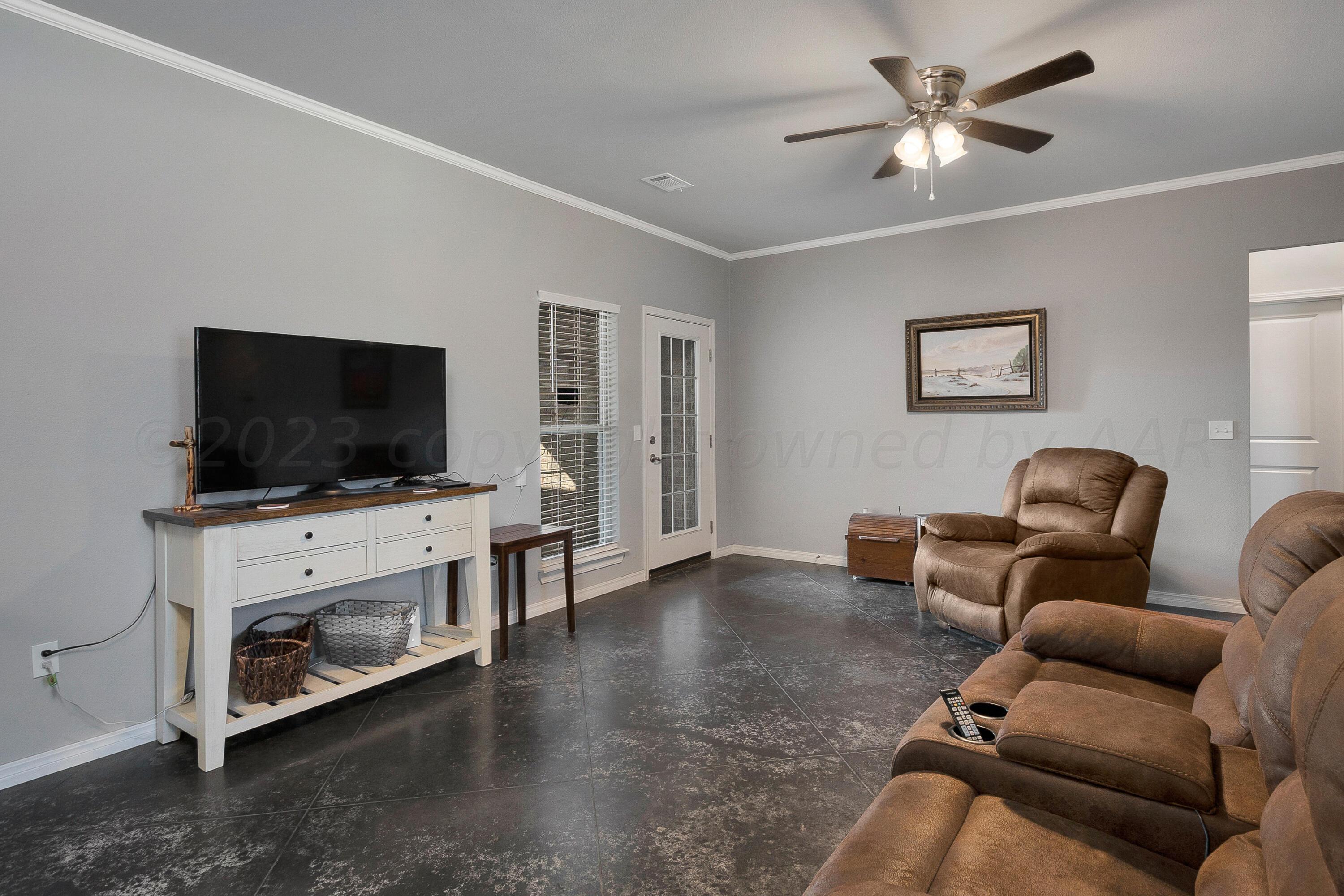9927 Perry Avenue Amarillo, TX 79119 - Photo 7 of 24 a living room with furniture and a flat screen tv