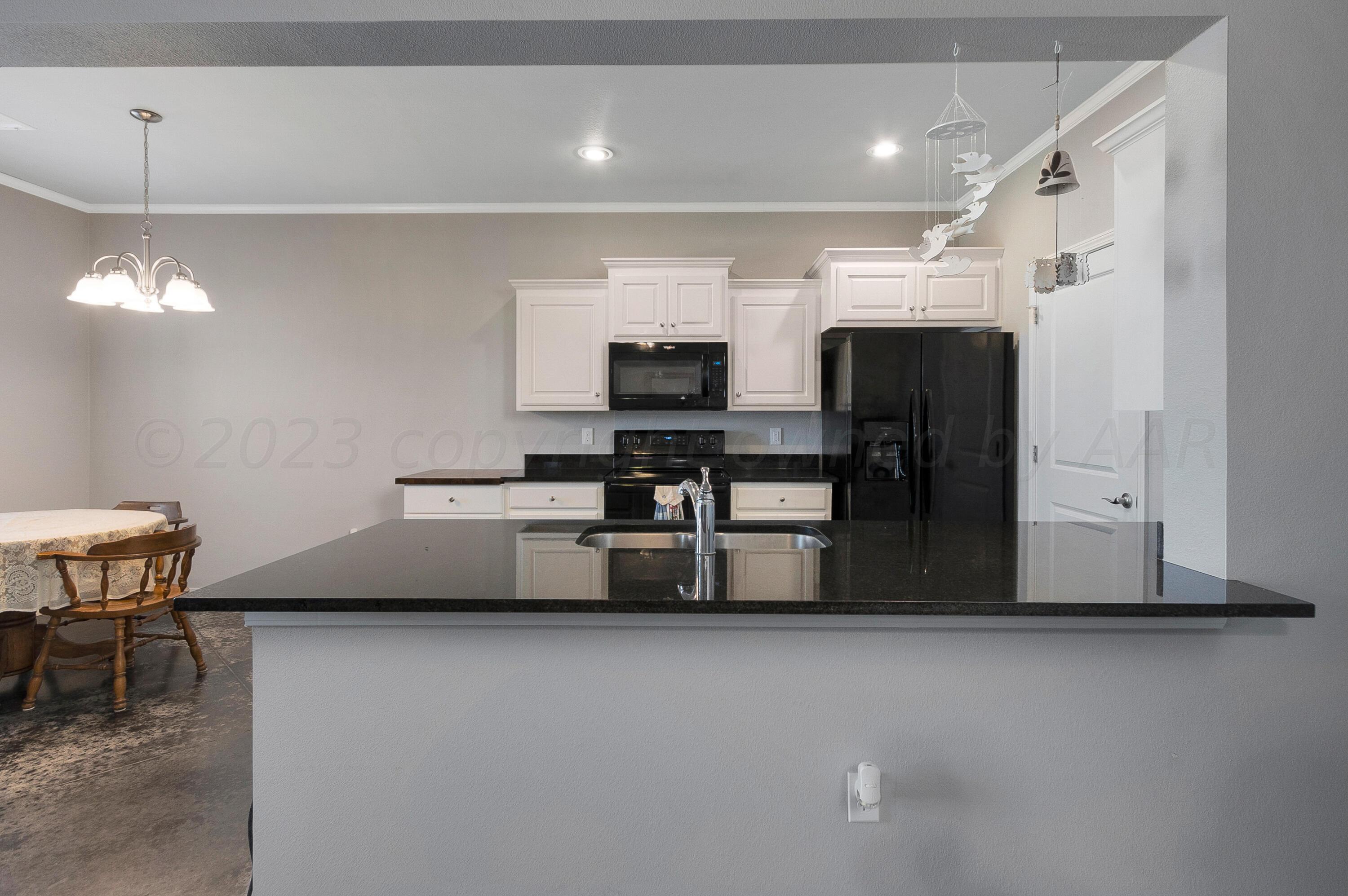 9927 Perry Avenue Amarillo, TX 79119 - Photo 8 of 24 a living room with furniture and a flat screen tv