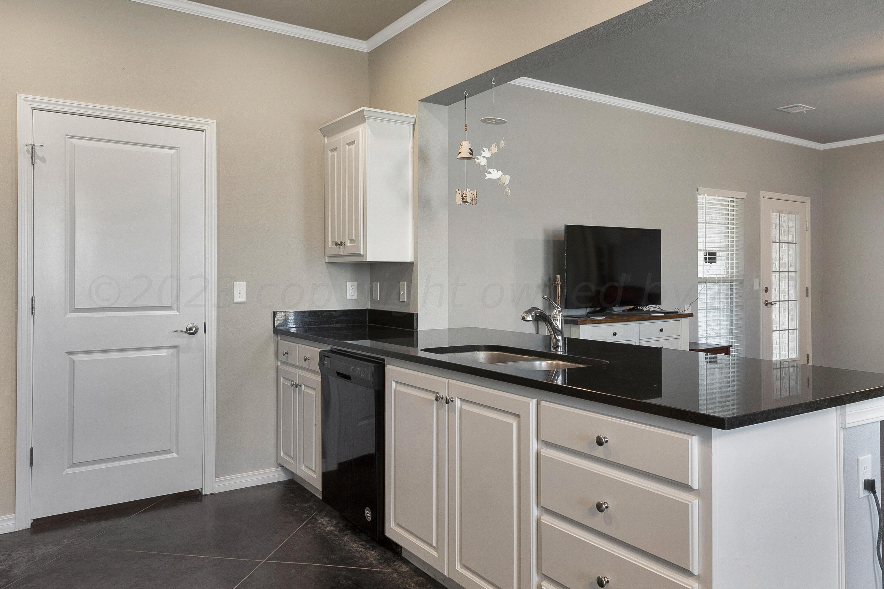 9927 Perry Avenue Amarillo, TX 79119 - Photo 10 of 24 a kitchen with stainless steel appliances granite countertop a sink and a stove top oven with white cabinets