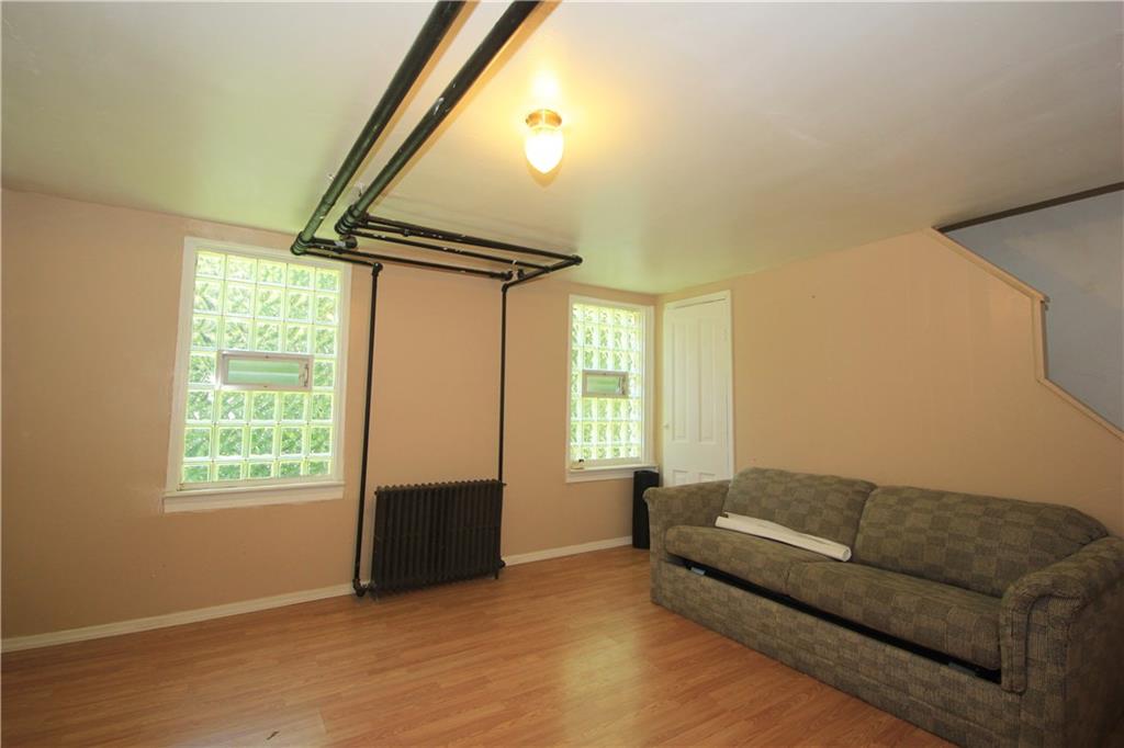 1360 Center Street McKees Rocks, PA 15136 - Photo 12 of 19 This is the lower level family room with laminate wood flooring and finished walls and ceiling. There are glass block windows for added security.