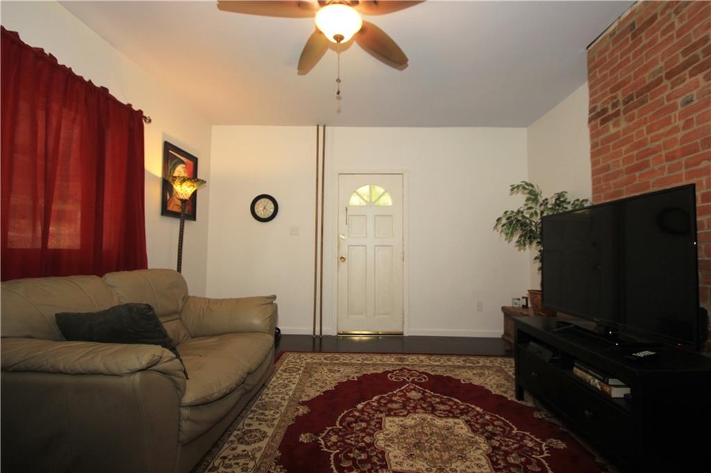 1360 Center Street McKees Rocks, PA 15136 - Photo 4 of 19 This alternate view of the living room shows the main entry door which leads to the side porch. There is a better view of the decorative fireplace and the lighted paddle fan. the windows treatments are included in the sale.