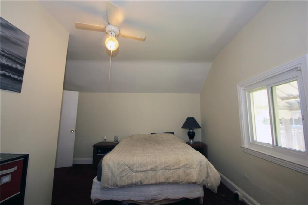 1360 Center Street McKees Rocks, PA 15136 - Photo 10 of 19 This is the second bedroom on the upper floor with plush carpet and neutral tone walls. The window showers the room in natural light and there is a lighted paddle fan for the evening hours. The spacious closet completes the room.