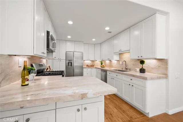 a kitchen with a sink a stove cabinets and counter space