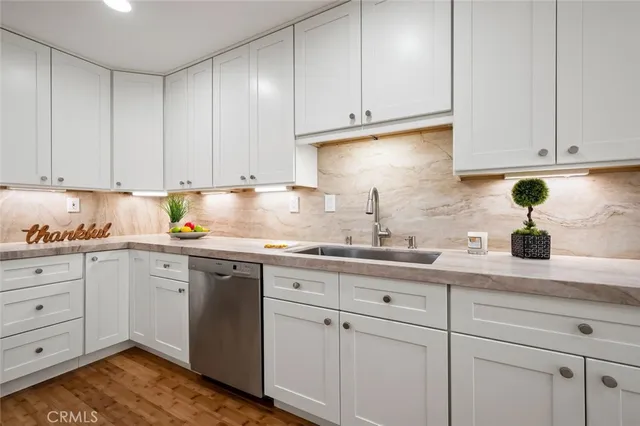 a kitchen with white cabinets and sink