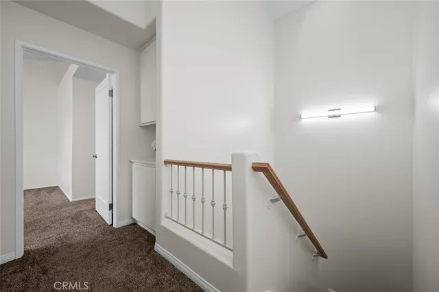 an empty room with chandelier fan and windows