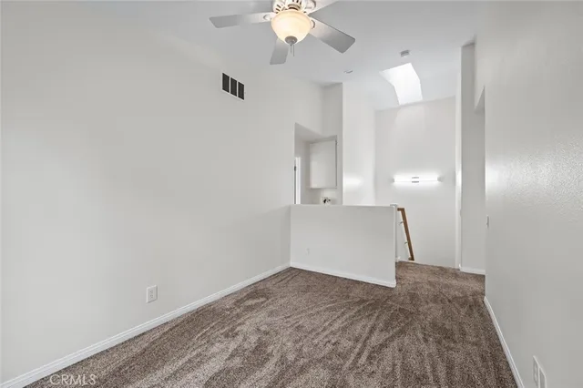 an empty room with window and ceiling fan