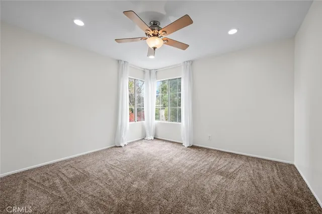 an empty room with a ceiling fan and a window