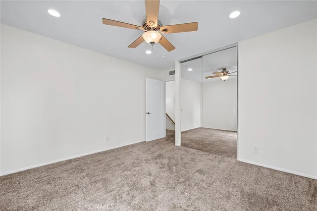 an empty room with a window and a fan