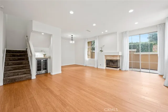 an empty room with wooden floor a fireplace and entryway